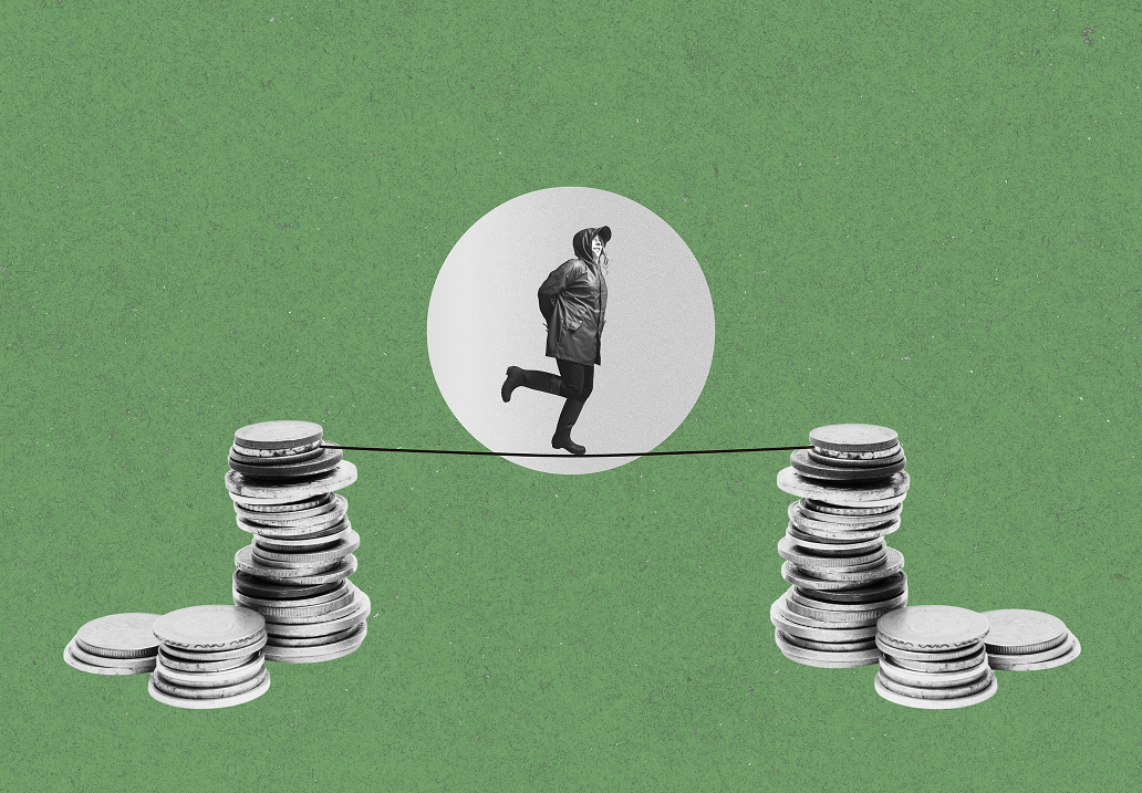 A collage on a green textured background: a black-and-white figure in a hooded raincoat and cap walks a tightrope strung between two tall stacks of coins, framed by a pale circle behind them, with smaller coin piles at the base of each stack.